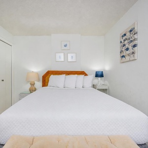 Enjoy a restful sleep on a queen bed, surrounded by soft linens and serene coastal decor in the guest room