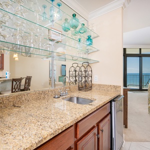 Wet bar with granite countertops, a blender, and a view of the tranquil coastline through large windows