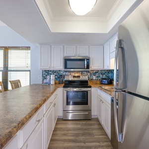 Colorful modern kitchen featuring stainless appliances, granite countertops, and a cozy dining area by the window
