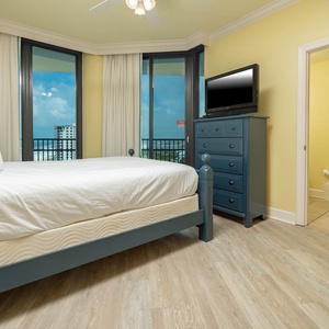 Relax in this guest bedroom with a queen bed, vibrant decor, and large windows offering a refreshing view