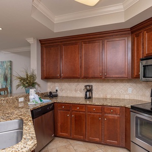 The kitchen features rich wood cabinetry, stainless appliances, and a convenient coffee maker for a delightful experience