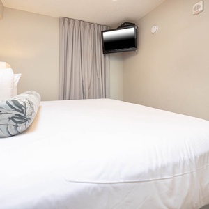 Rest on the king bed with soft linens, while enjoying your favorite shows on the mounted flat-screen TV