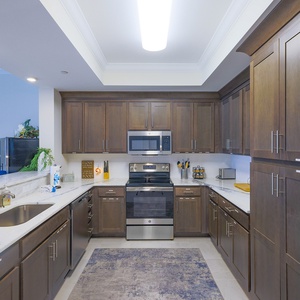Prepare meals in this stylish kitchen with rich wooden cabinetry, stainless appliances, and fun coastal decor
