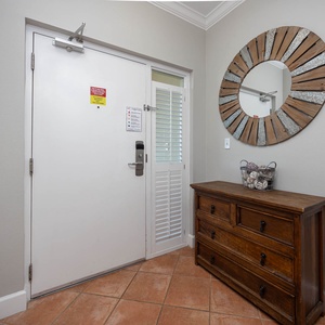 Step into a welcoming entryway highlighted by natural light and charming decor, setting the tone for your stay