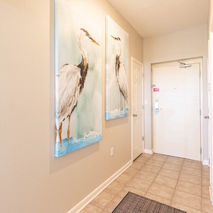 Welcoming entryway featuring serene bird artwork, tile flooring, and a door leading to the vacation rental's main living area