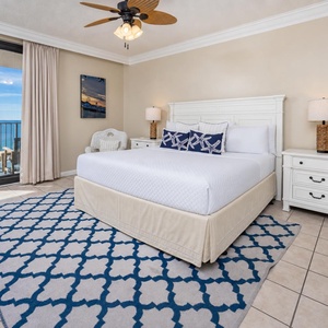 Unwind in this inviting master suite featuring a plush king bed, coastal decor, and direct access to beautiful beach views