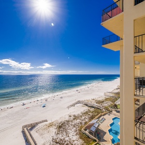 Stunning view from the balcony showcasing white serene beaches and sparkling waters under a bright blue sky
