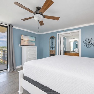 White linens cover the king bed as you catch up on shows with coastal sounds from your balcony
