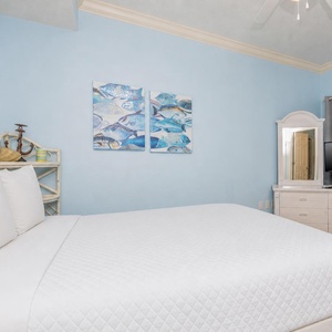 Experience blissful sleep in a serene guest bedroom with soft queen bedding and a TV for your favorite shows