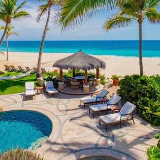 Patio with pool, lounge chairs and beachfront view