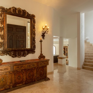 Ornate mirror and furniture with stairway to bedrooms