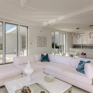 Unwind in your elegant open-plan living space where white furnishings meet sleek modern design, creating the perfect sanctuary for relaxation.