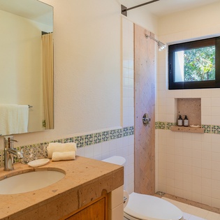 Your private bathroom features marble countertops, stylish mosaic tiles, and natural light streaming through garden views.