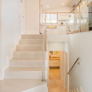 Ascend elegant glass-railed stairs to your bright, multi-level retreat with stunning kitchen views and warm modern finishes throughout.