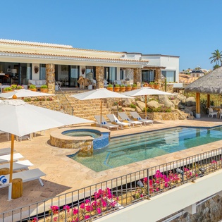 This stunning beachfront villa features a sparkling pool, spa, and elegant outdoor entertaining areas surrounded by tropical landscaping.