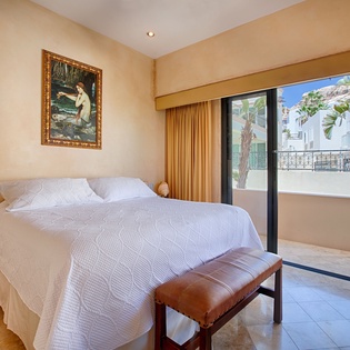 You'll love waking up in this serene bedroom with soft linens and sunlight streaming through the balcony doors. Step outside to enjoy your morning coffee surrounded by palm trees.