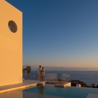 Modern oceanfront villa with infinity pool overlooking endless sea views at golden hour.