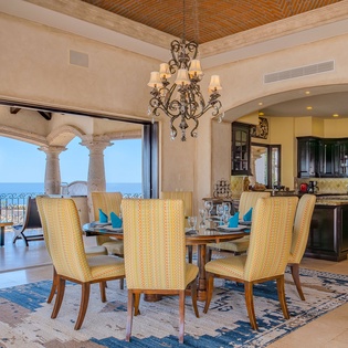 Gather around this elegant dining table where memorable meals unfold beneath a stunning chandelier, with your private terrace and ocean views creating the perfect backdrop.