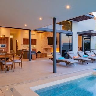 Relax poolside while gazing into your open-concept kitchen and dining area, where warm wood tones create the perfect backdrop for vacation meals.