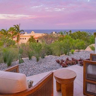 Watch the sky transform into soft pinks and purples from your private terrace, where comfortable seating and desert garden views create the perfect evening retreat.