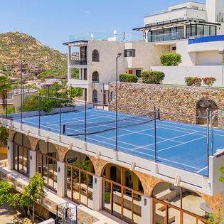 This elevated tennis court sits atop arched architecture, surrounded by palm trees and mountain views. Active guests enjoy year-round play in a scenic outdoor setting, combining sport with striking desert-meets-coast scenery.