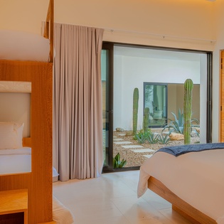 Your modern bedroom opens to desert tranquility with rich wood furnishings and serene garden views.
