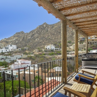 Unwind on your private terrace with stunning mountain views, where comfortable loungers and dining space create the perfect hillside retreat.