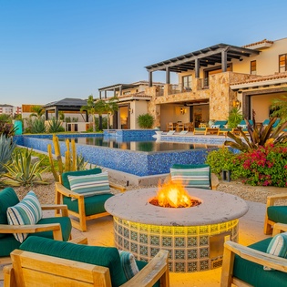 Stunning villa with desert fire pit and infinity pool creates the perfect evening retreat in tropical paradise.