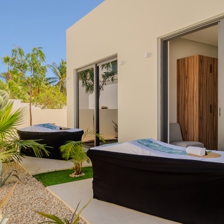 Your private outdoor spa sanctuary awaits with luxurious soaking tubs surrounded by tropical palms and modern architecture.