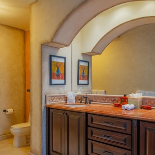 Luxurious bathroom featuring dual vanities, elegant archways, and warm stone finishes create your perfect morning routine.