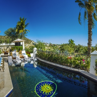 Your private pool oasis awaits with stunning mountain views, tropical palms swaying overhead, and luxurious loungers for ultimate relaxation.