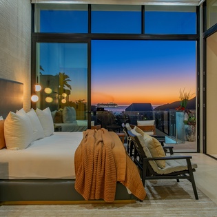Wake up to stunning sunrise views from your luxurious bedroom, where floor-to-ceiling windows frame golden skies and modern comfort meets breathtaking scenery.