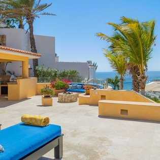 Stunning rooftop terrace with ocean views, comfortable loungers, and tropical palms - your perfect paradise retreat.