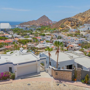 Elevated coastal property nestled between vibrant hillside neighborhoods and the sea, with scenic mountain backdrop and marina views defining the surrounding area.