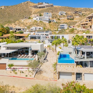 Modern hillside villas showcase stunning architectural design with private pools nestled among desert landscape and tropical palms.