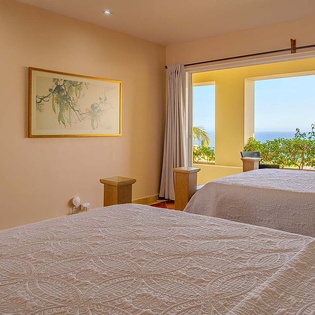 Wake up each morning to a breathtaking ocean view framed by lush greenery. Your restful retreat offers twin beds, soft linens, and a peaceful ambiance perfect for unwinding after a day of coastal adventures.