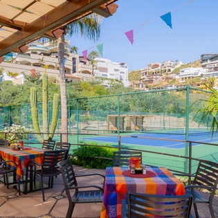 Colorful terrace overlooking the tennis court, perfect for morning coffee or evening tapas with tropical views.