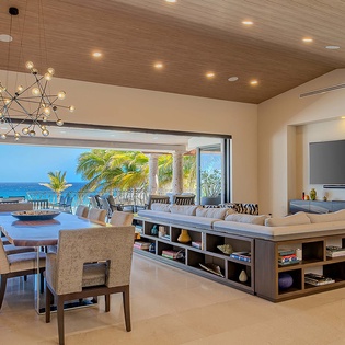 Relax in this open-concept living and dining space framed by stunning ocean views, where modern elegance meets seamless indoor-outdoor living for your ideal coastal retreat.