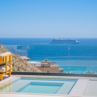 Breathtaking sea views stretch endlessly from this hillside terrace, featuring a pristine pool and luxury daybed for ultimate relaxation.
