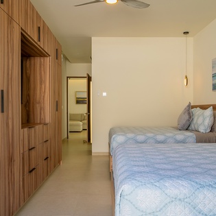 Unwind in your serene twin bedroom with elegant wood cabinetry, soft lighting, and thoughtful coastal touches that create the perfect retreat.