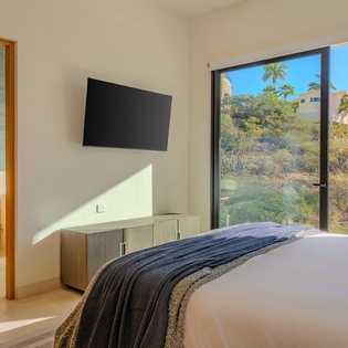Wake to stunning hillside views through floor-to-ceiling windows. Your modern bedroom features contemporary furnishings and an elegant ensuite.