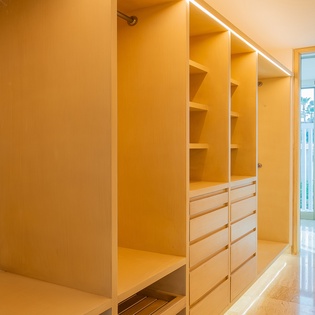 Your spacious walk-in closet offers abundant storage with custom shelving and drawers, plus natural light streaming from your private balcony.