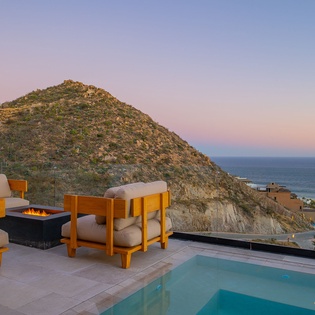 Stunning terrace with pool, firepit seating, and breathtaking ocean views creates the perfect evening retreat.