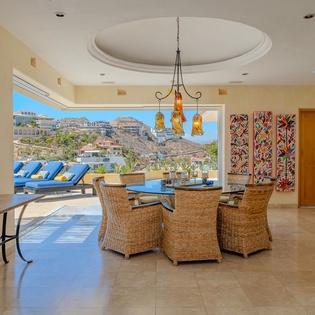 Relax in your elegant dining space with stunning mountain and pool views through expansive windows, perfect for memorable meals.