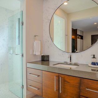 Step into your private spa-like bathroom with sleek marble walls, a spacious walk-in shower, and a stylish vanity topped with premium amenities.