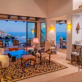 Living area with ocean views and patio access at night