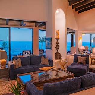 Living area with ocean views and patio access at night