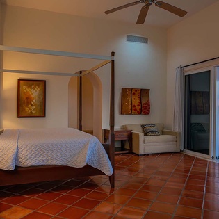 Step into your serene bedroom oasis with a four-poster canopy bed and stunning ocean views framed by glass doors opening to your private terrace.