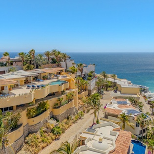 Stunning beachfront community featuring luxury villas and pristine coastline surrounded by swaying palm trees and crystal-clear waters.