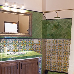 Your private bathroom enchants with vibrant green tiles and colorful Moroccan patterns, creating a spa-like sanctuary for your daily rituals.